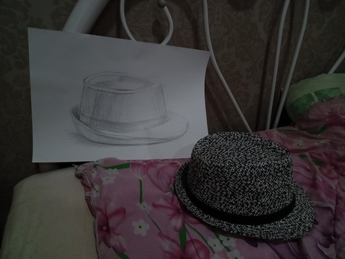 drawing of a hat, with said hat nearby